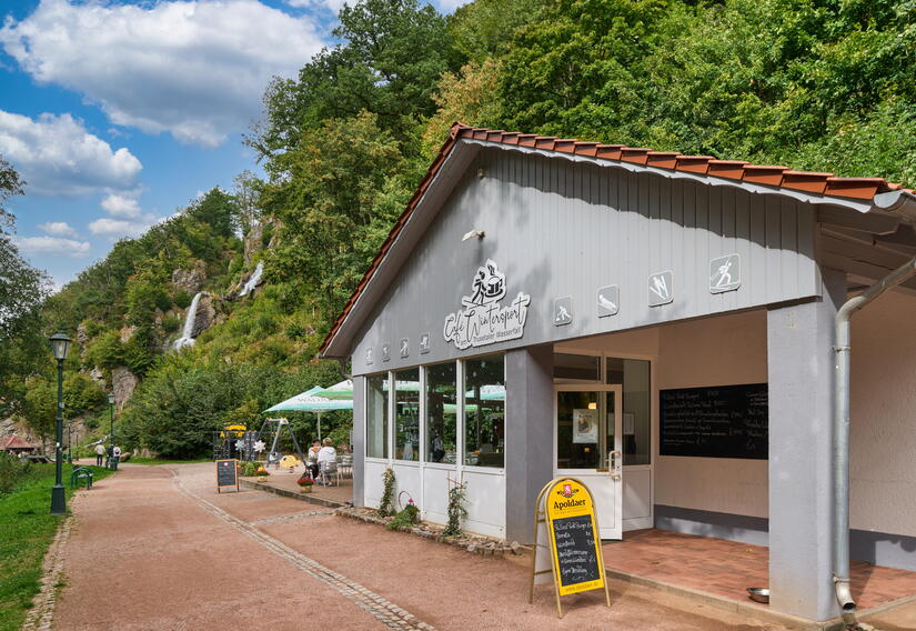 Café mit Blick auf den Trusetaler Wasserfall und Terrasse mit Sitzgelegenheiten und Sonnenschirmen