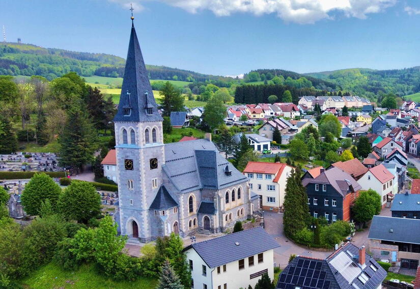 Blick auf die Kirche in Brotterode aus der Vogelperspektive, links im Hintergrund der Inselsberg