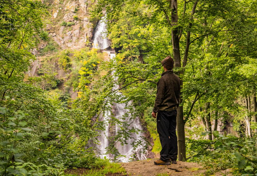 Wanderer blickt auf den Wasserfall