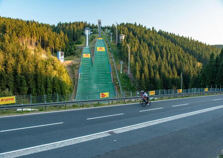 Radfahrer mit Gravelbike passieren die Schanzen in Oberhof