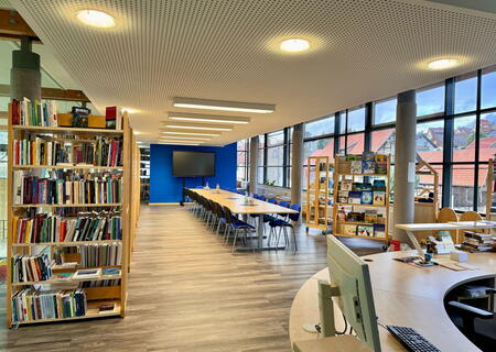 Blick in die Bibliothek mit Bücherregalen und Lesetisch im Rathaus Trusetal.