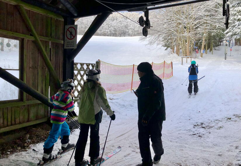 Wintersportler mit Ski am Skilift in Laudenbach