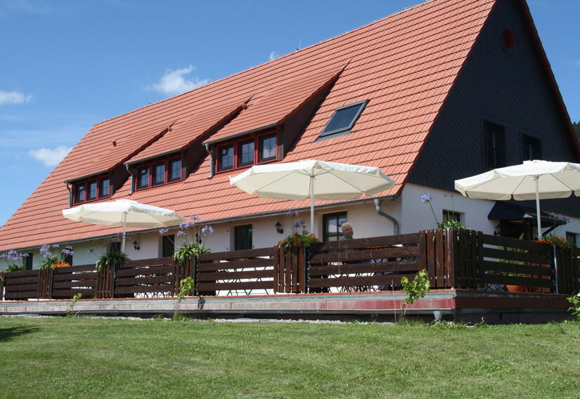 Terrasse mit Sonnenschirmen, dahinter das Café Ober der Eller