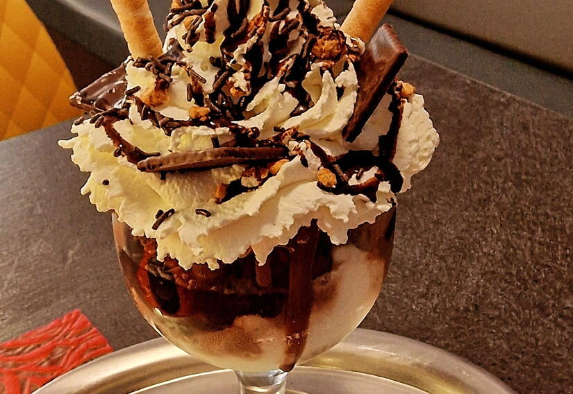 Schokoladeneisbecher mit Sahne auf Tablett