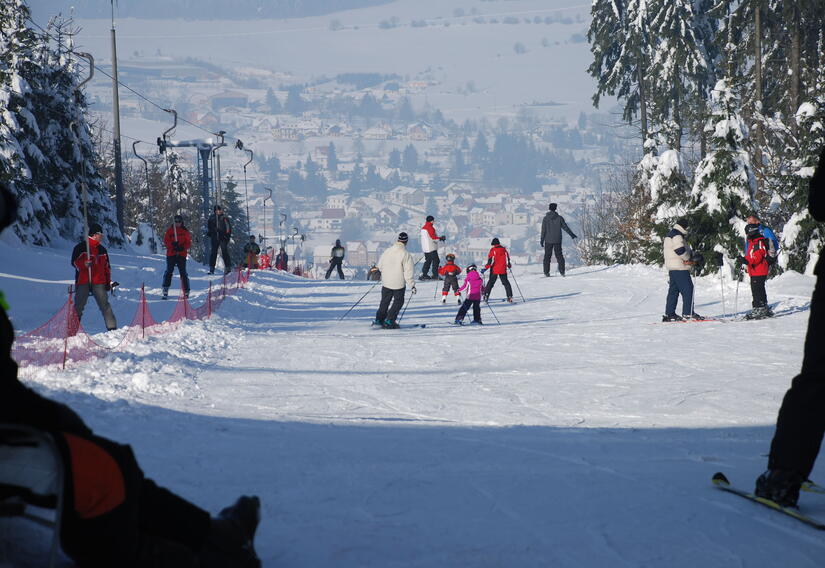 Familien mit Skiern am Abfahrtshang