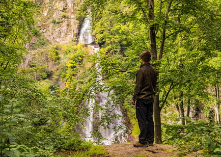 Wanderer blickt auf den Wasserfall