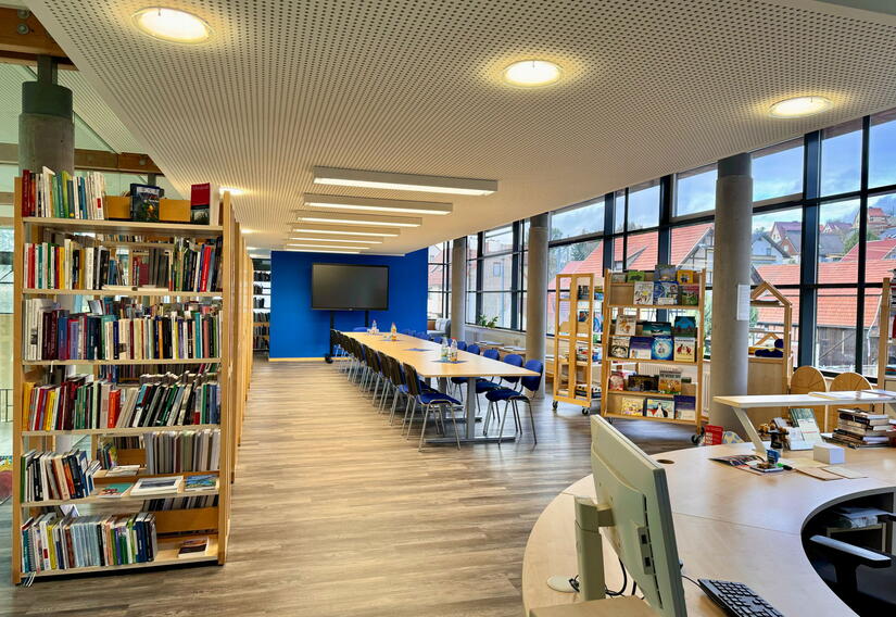 Blick in die Bibliothek mit Bücherregalen und Lesetisch im Rathaus Trusetal.